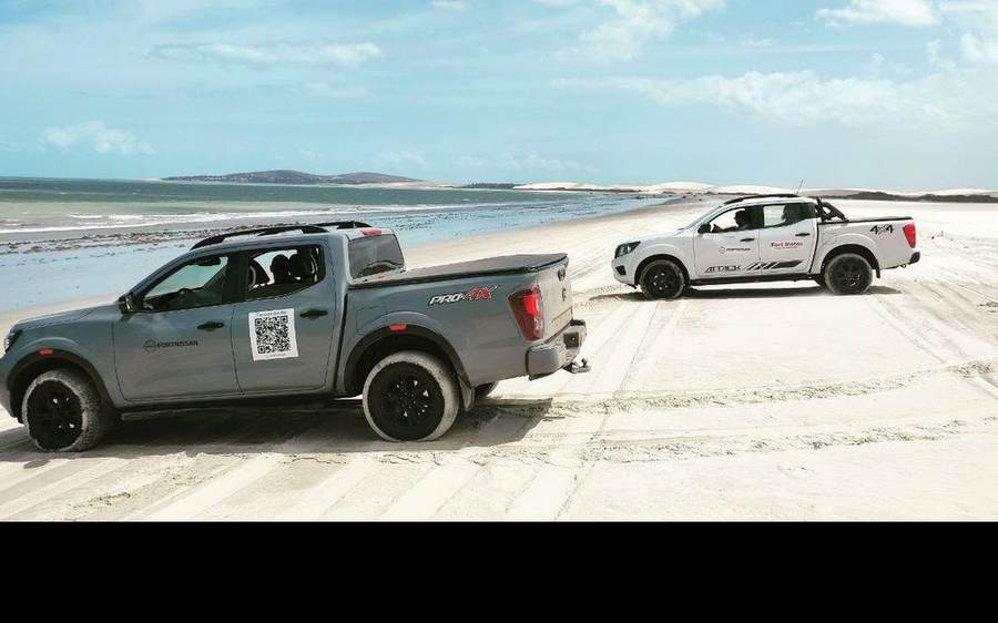 Zwei Gelaendewagen am Strand der Nordostkueste